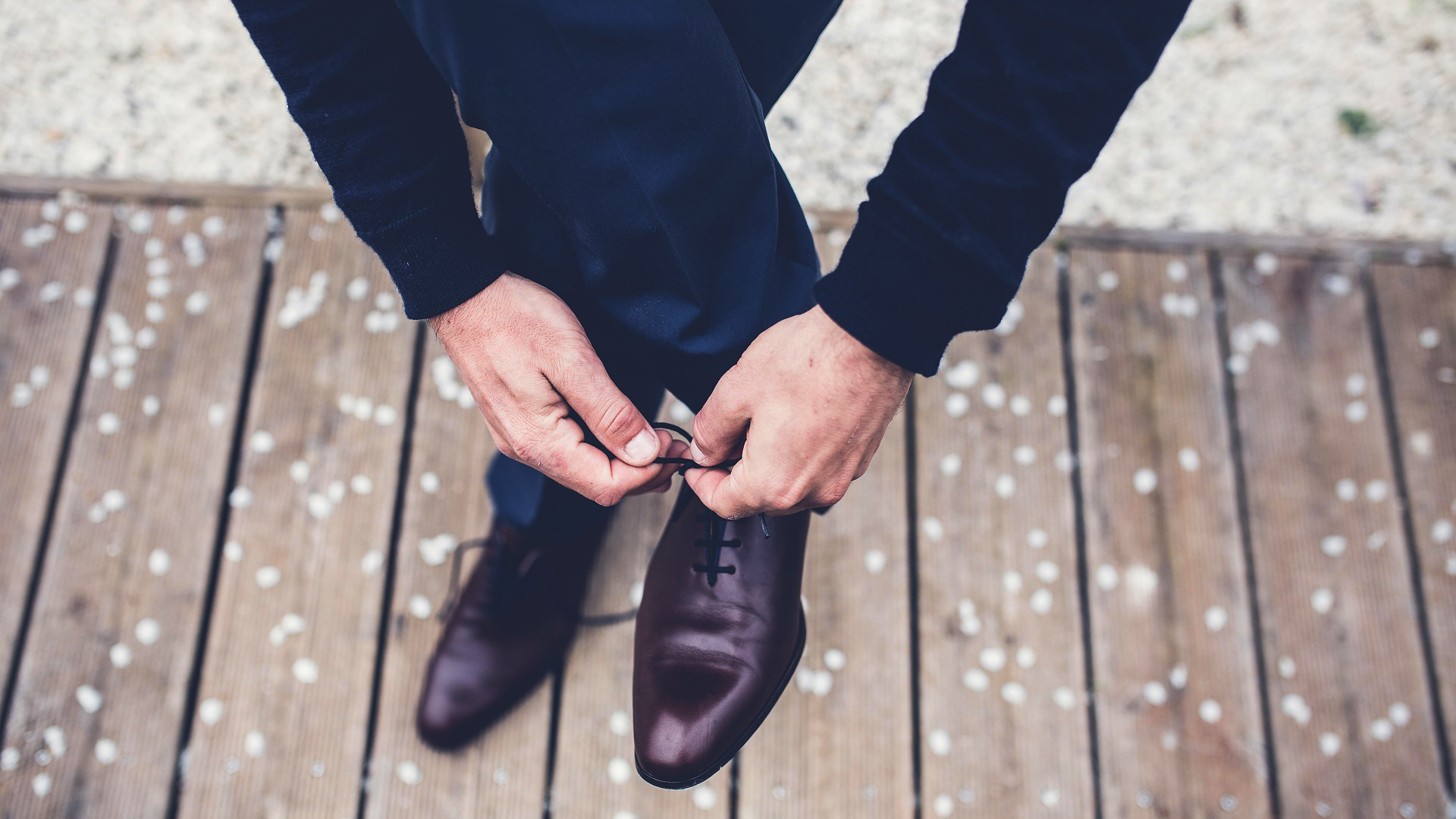 Busy professional tying dress shoes after receiving a HealthyNails™ clinical pedicure in Austin