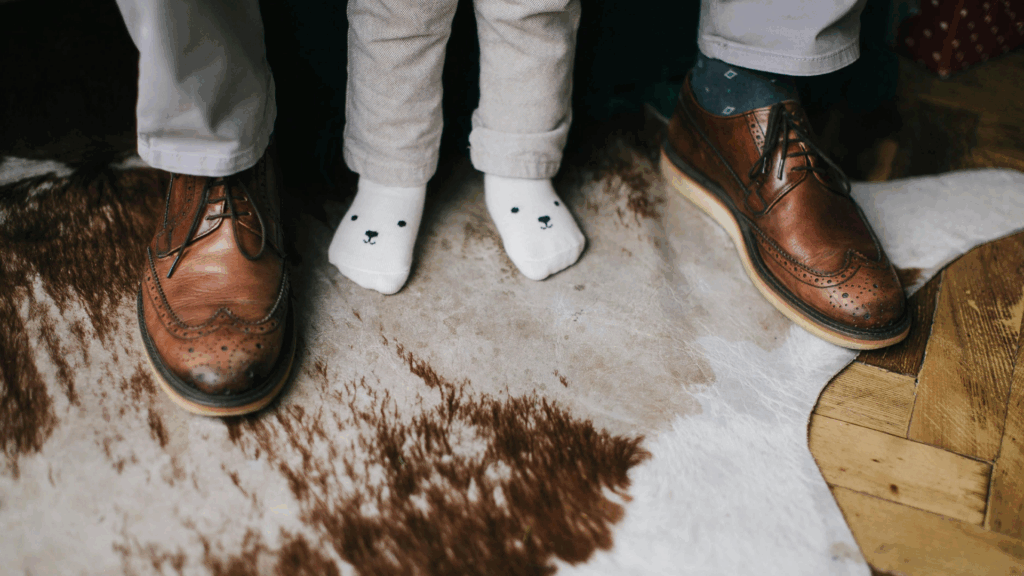 Parent and child’s feet together, highlighting HealthyNails™ safe pedicure care for young parents in Austin